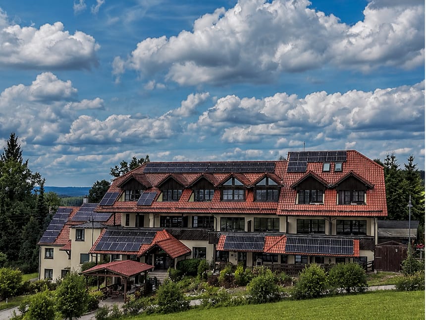 Umweltfreundliches Gebäude mit Solaranlagen und rotem Dach.