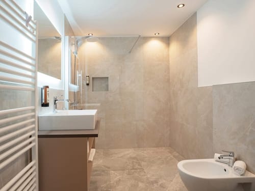 Modernes Badezimmer mit eleganter Fliesengestaltung und geräumiger Dusche.