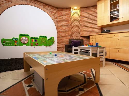 Gemütliches Spielzimmer mit Wandspielen und Kindermöbeln aus Holz