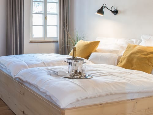 Elegantes Schlafzimmer mit gemütlichem Doppelbett und Champagner.