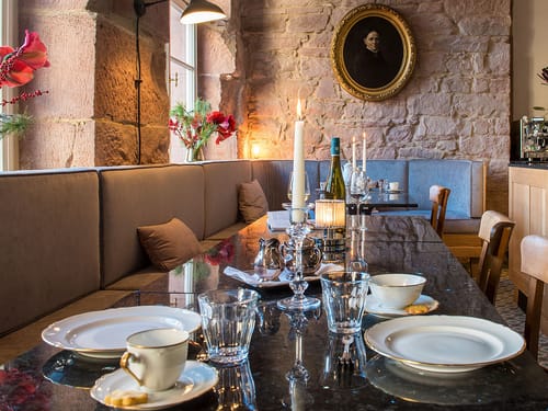 Elegantes Restaurant mit festlich gedecktem Tisch und Porträt an der Wand