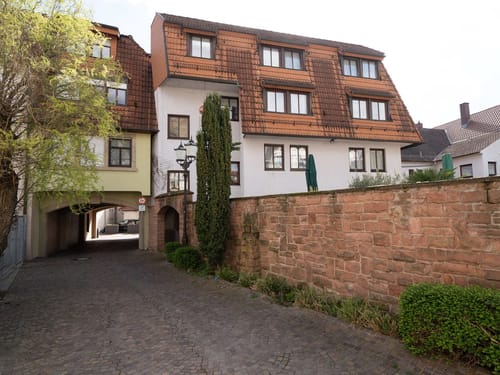 Historisches Gebäude mit Durchgang und Natursteinmauer in einer malerischen deutschen Altstadt.