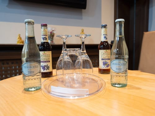 Hochwertige Wasserflaschen und köstliche Erfrischungsgetränke auf einem Tisch präsentiert. Perfekt für Meetings, Veranstaltungen und private Feiern.