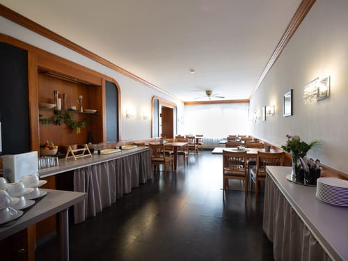 Frühstücksraum in einem Hotel mit gedeckten Tischen und Buffet