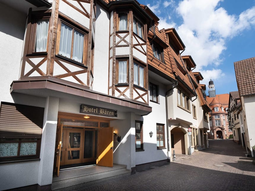 Traditionelles Hotelgebäude mit Holzbalken und Fachwerkfassade in einer malerischen Straße.