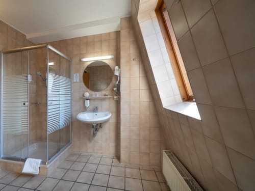 Modernes Badezimmer mit Duschkabine, Waschbecken und Dachfenster
