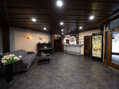 Eleganter Hotellobbybereich mit Rezeption, Klavier und Sofa