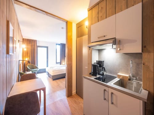 Gemütliches Hotelzimmer mit Küche und Holzwänden