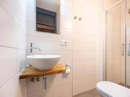 Modernes Badezimmer mit Waschbecken, Spiegel und Dusche
