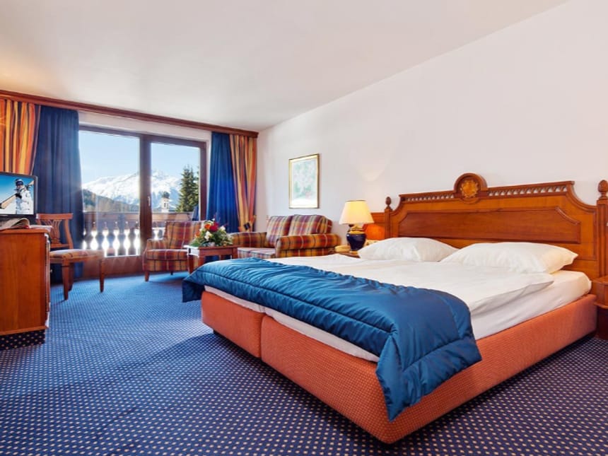 Doppelbett, Sitzbereich und traumhaftem Bergpanorama durch großzügige Balkontür