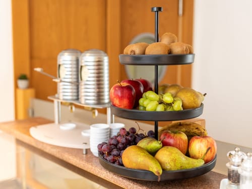 Obstarrangement mit Kiwi, Apfel, Trauben und Birnen auf einer Etagere