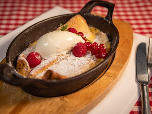 Leckere Pfannkuchen mit Eis und Beeren in einer gusseisernen Pfanne