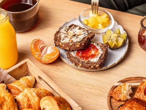 Genussvolles Frühstück mit Vollkornbrot, Croissants und frischen Früchten