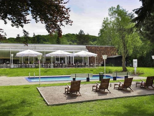 Hotel Außenbereich mit Pool und Terrasse – Entspannung im Grünen