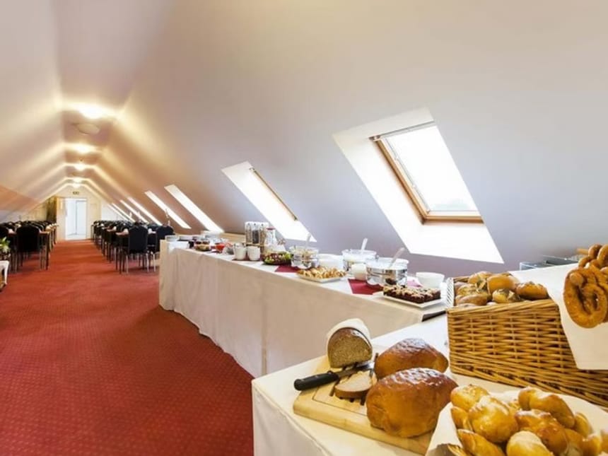 Eleganter Frühstücksraum mit Buffet und Sitzgelegenheiten im Dachgeschoss eines Hotels.