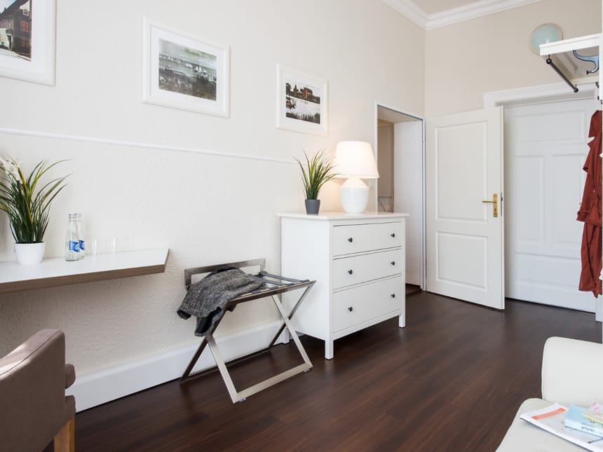 Helles Interieur eines modernen Zimmers mit weißen Möbeln und Holzboden