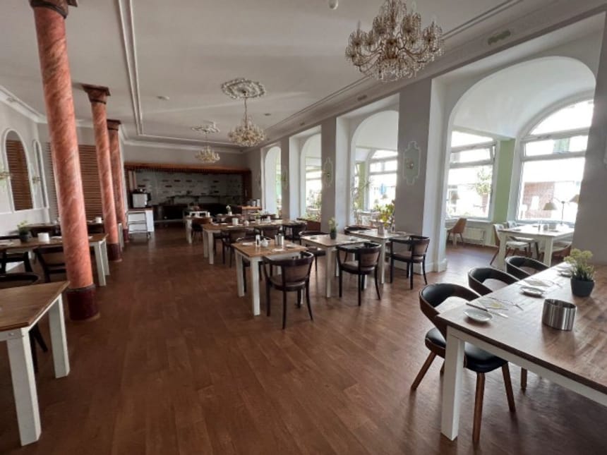 Elegantes Restaurantinterieur mit Holzboden und Kronleuchtern