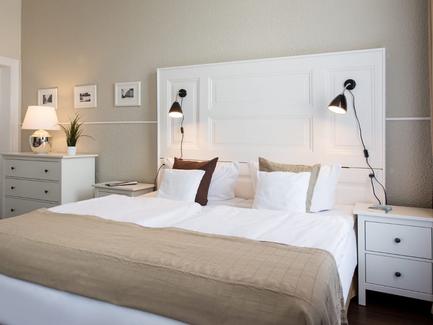 Modernes Schlafzimmer mit elegantem weißem Doppelbett und stilvollem Interieur