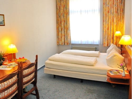 Hotelzimmer mit Einzelbett und klassischer Einrichtung