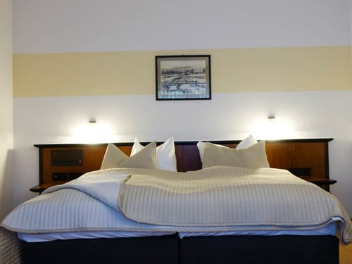 Komfortables Hotelzimmer mit Doppelbett und stimmungsvoller Beleuchtung