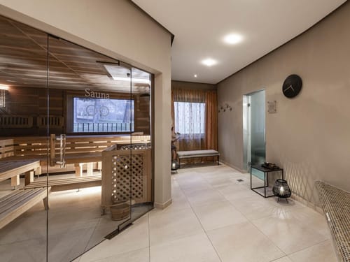 Moderner Sauna- und Wellnessbereich mit Glasfront und Holzbänken.