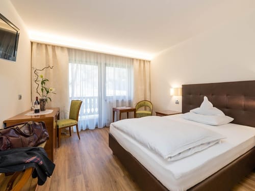 Gemütliches Hotelzimmer mit großem Bett und Holzmöbeln