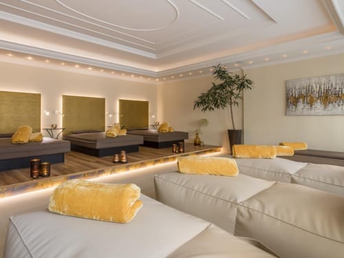 Entspannungsbereich in einem luxuriösen Spa mit gemütlichen Liegen und gedämpftem Licht