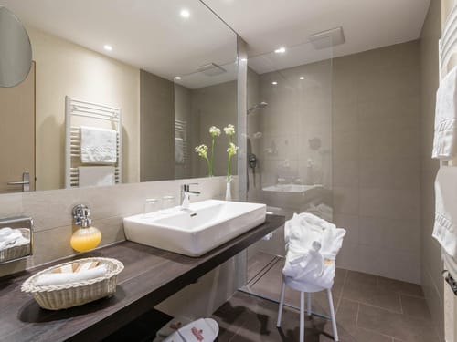 Modernes Badezimmer mit Waschbecken, Glasdusche und Handtuchhalter