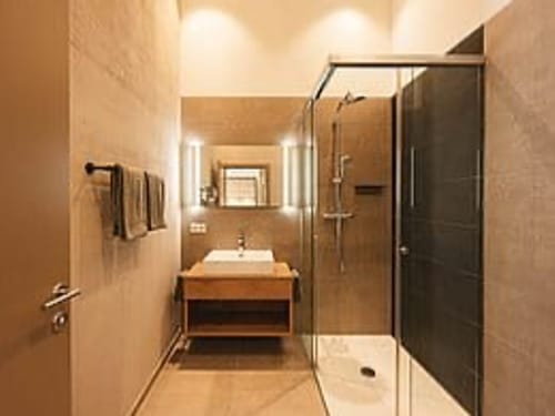 Elegantes Badezimmer mit Duschkabine und Holzwaschtisch