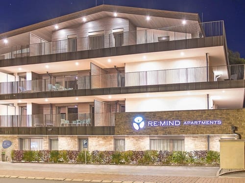 RE:MIND Apartments – Modernes Apartmentgebäude bei Nacht