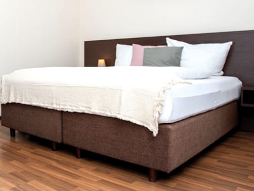 Boxspringbett Braun – Komfortables Doppelbett mit weißer Bettwäsche