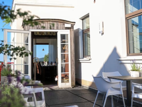 Gemütliche Außenterrasse eines Restaurants mit Blick ins Innere