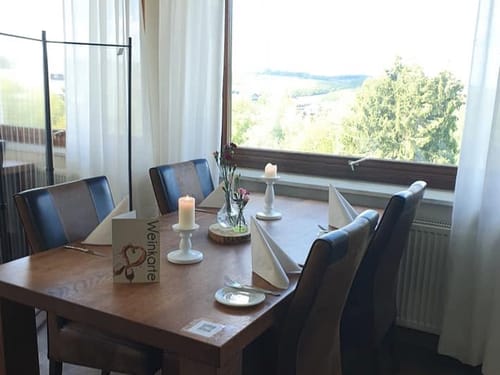 Restauranttisch mit Aussicht – romantisches Ambiente mit Weinkarte und Kerzenlicht