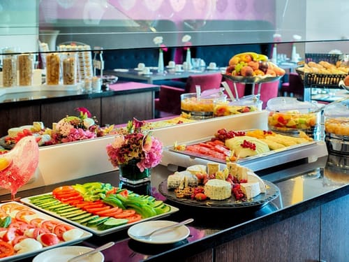 Frühstücksbuffet mit frischem Gemüse, Käse, Obstplatten und Backwaren