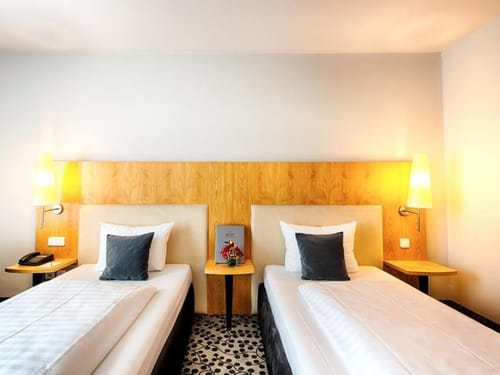 Komfortables Zweibettzimmer mit moderner Holzverkleidung und warmem Ambiente