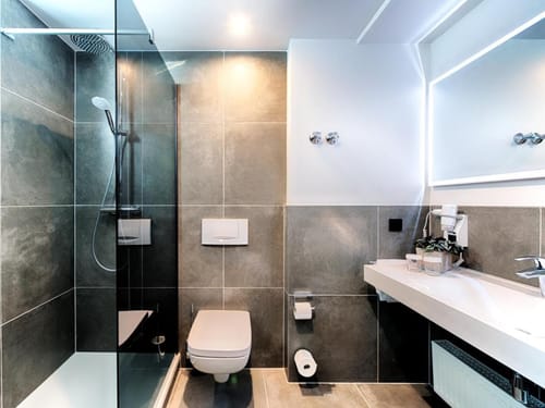 Komfortables Hotelbadezimmer mit hochwertiger Ausstattung, Glasdusche und stilvollem Lichtkonzept
