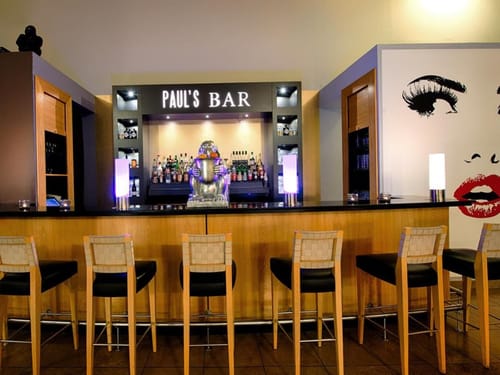 Paul's Bar – Elegante Bar mit stimmungsvoller Beleuchtung, großer Getränkeauswahl und moderner Wandkunst