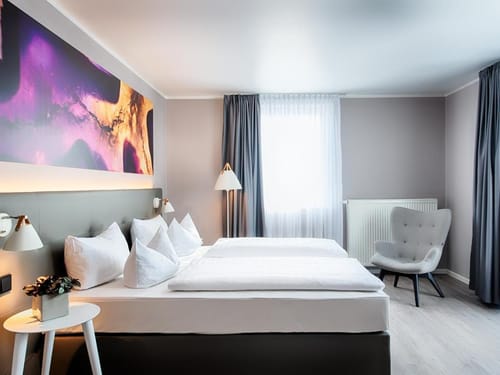 Komfortables Doppelzimmer mit modernem Interieur, stimmungsvoller Beleuchtung und exklusiver Kunstdekoration für einen erholsamen Aufenthalt