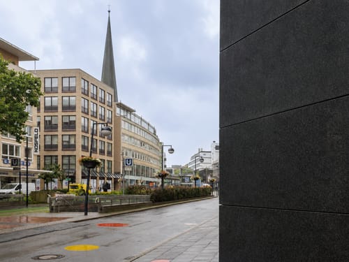 Städtische Fußgängerzone mit Kirchturm und U-Bahn-Station in der Innenstadt