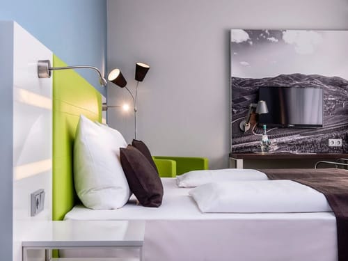 Komfortables Doppelzimmer mit modernem Design, stilvollen Akzentfarben in Grün und Braun sowie regionaler Wanddekoration mit Weinbergmotiv