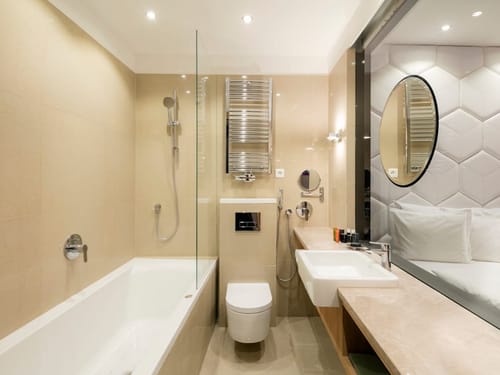 Hotelbadezimmer mit Badewanne, Regendusche und elegantem Waschtisch in modernem Beige-Design