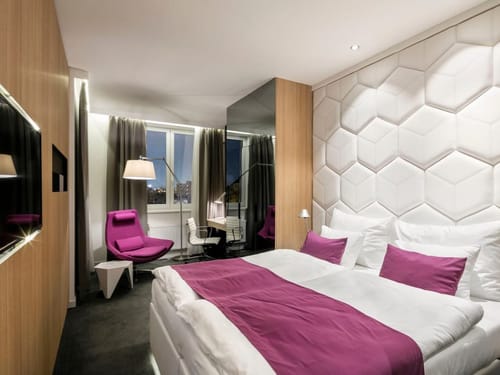 Doppelzimmer mit modernem Waben-Kopfteil und stilvollen Magenta-Akzenten für höchsten Wohnkomfort