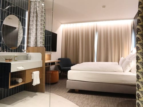 Elegantes Hotelzimmer mit offenem Bad und Doppelbett – modernes Interieur