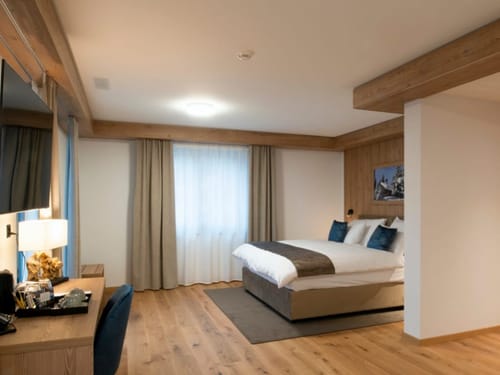 Alpines Hotelzimmer mit elegantem Holzinterieur und komfortablem Doppelbett