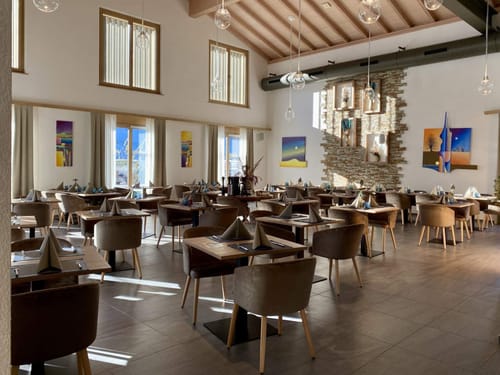 Eleganter Restaurantinnenraum mit stilvoll gedeckten Tischen und Kunstwerken