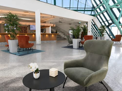 Elegante Hotellobby mit stilvollem Design und lichtdurchflutetem Glasdach