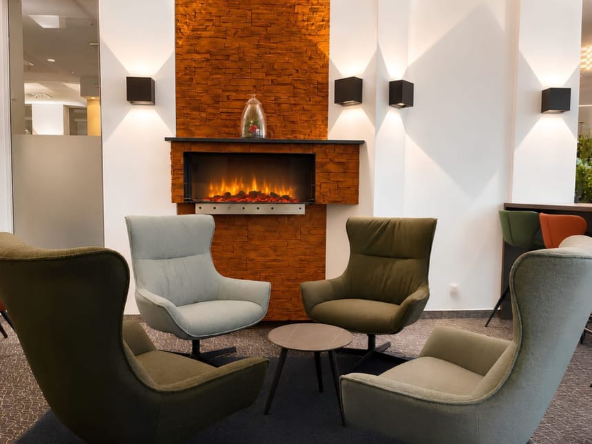 Gemütliche Lounge-Ecke mit Elektrokamin und Designer-Sesseln