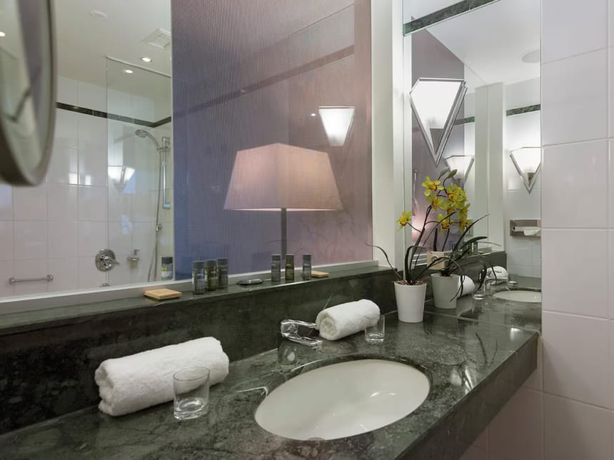 Luxuriöses Hotelbadezimmer mit Marmorwaschtisch und hochwertiger Ausstattung