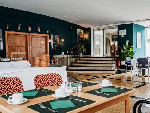 Gemütliches Hotelrestaurant mit stilvollem Interieur und gedeckten Frühstückstischen