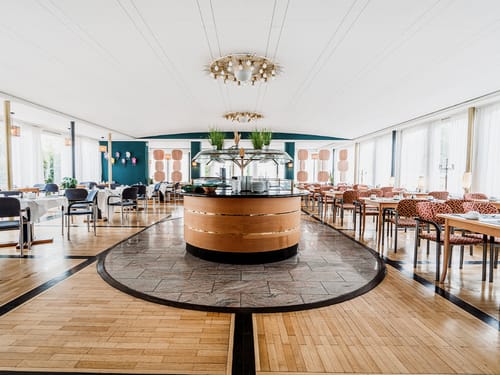 Stilvolles Hotelrestaurant mit zentralem Buffet und klassischem Interieur